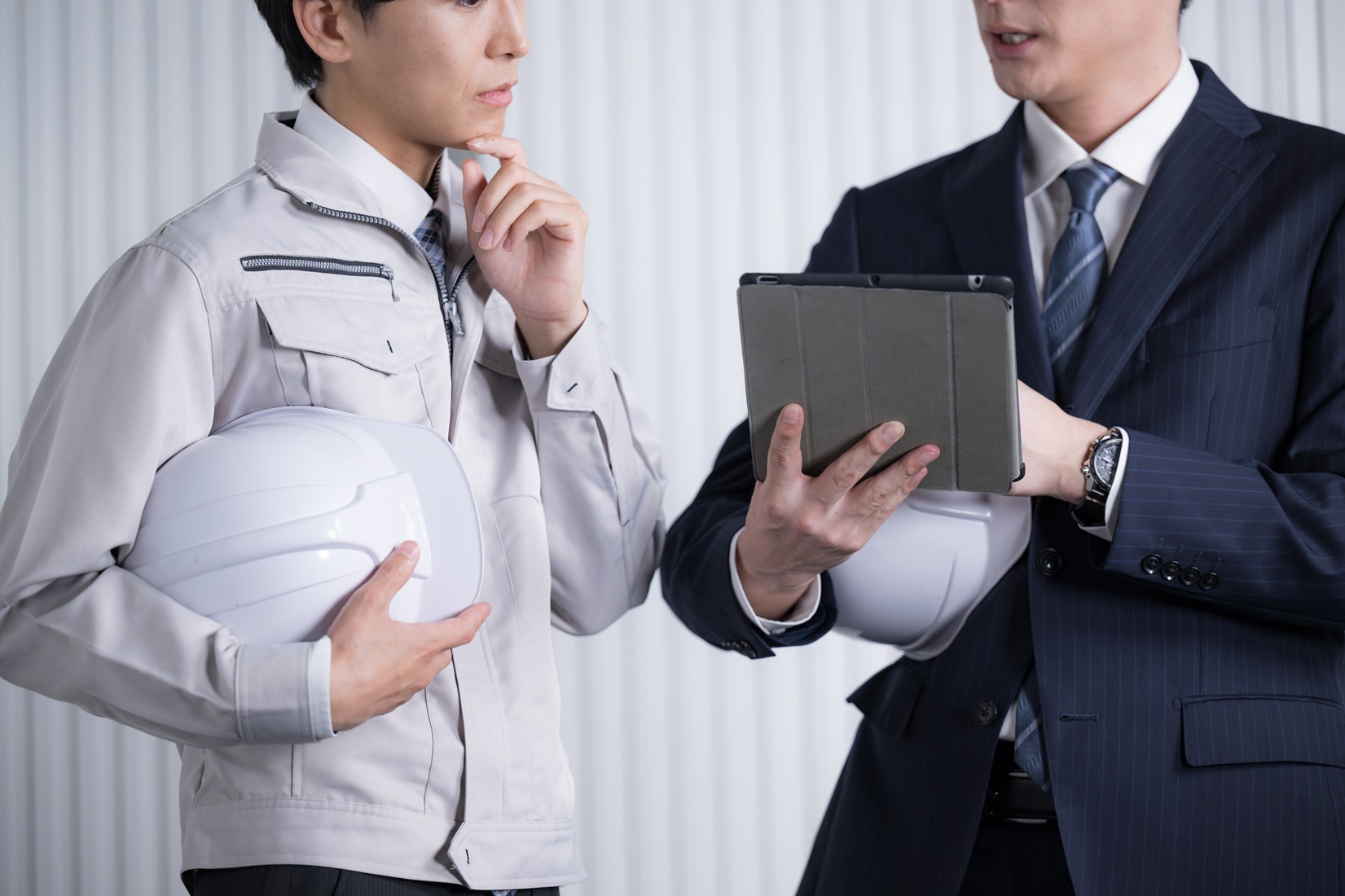 作業服姿の人とスーツ姿の人